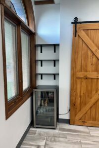 A small fridge with drinks, black shelves, and room for Skincare or Natural Nail Care essentials.