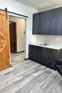 Modern office with gray cabinets, a sink, tile floor, and space for natural nail care.