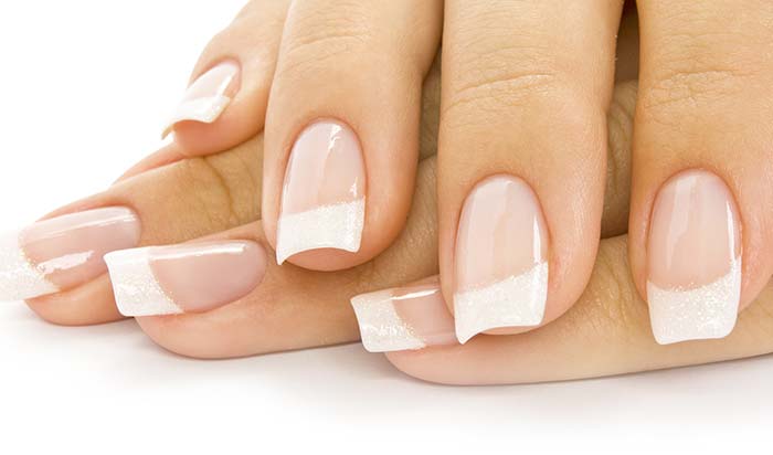 Close-up of hands with French manicure, squared acrylic nails, perfect after a rebalance session.